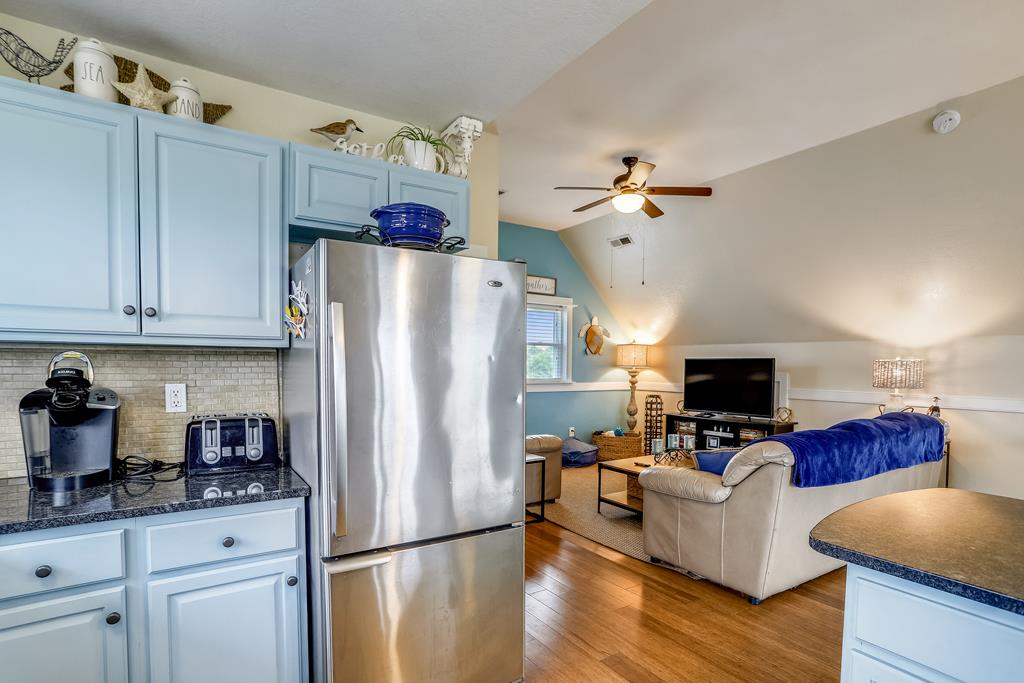 Settle into your cozy open-plan retreat, where a fully equipped kitchen flows seamlessly into a bright living space with warm wood floors and a calming coastal palette—perfect for unwinding after your adventures.
