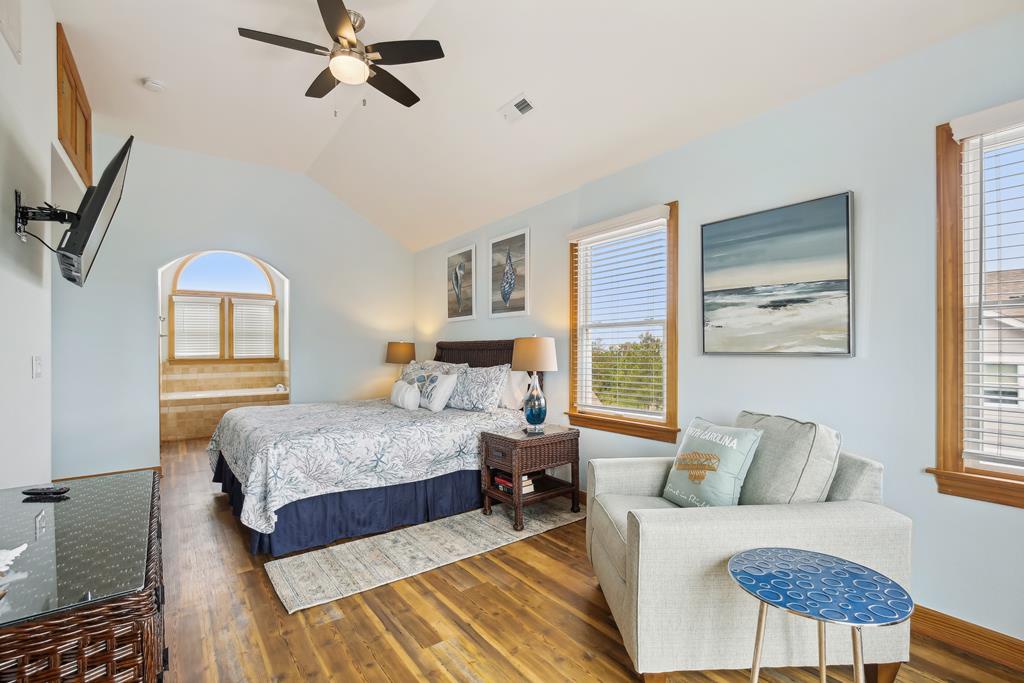 Your bright coastal retreat features vaulted ceilings, calming blue walls, and warm hardwood floors. Unwind on the plush bed or lounge area while enjoying sea-inspired artwork and natural light streaming through expansive windows.