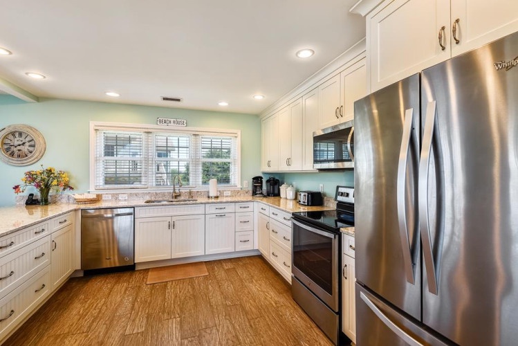 This bright kitchen welcomes you with gleaming countertops, modern stainless steel appliances, and plenty of space to prepare your favorite meals.