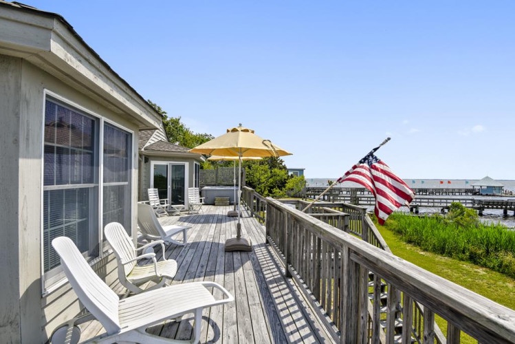 Waterfront deck overlooking the marina where you'll relax in classic Adirondack chairs, soaking up coastal breezes and the peaceful rhythm of life by the water.