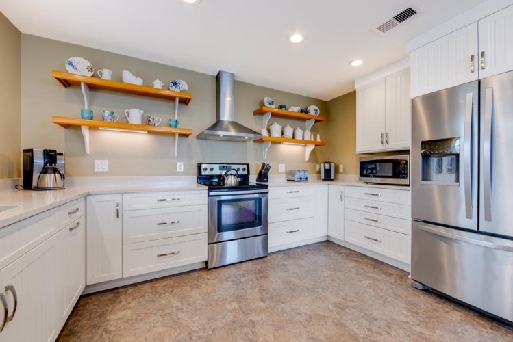 Whip up your favorite meals in this fully-equipped kitchen featuring stainless steel appliances, ample counter space, and open shelving for easy access to everything you need.