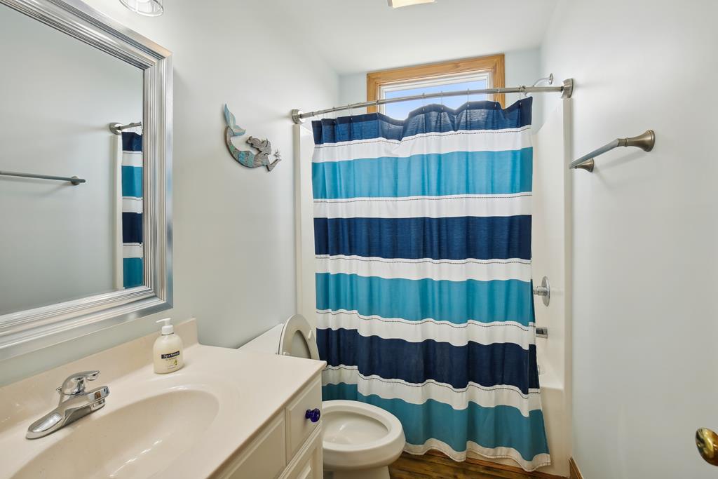Your private bathroom features a full bath-shower combo with cheerful nautical stripes, plus a vanity with mirror and all the essentials you need to feel refreshed and ready for your day.