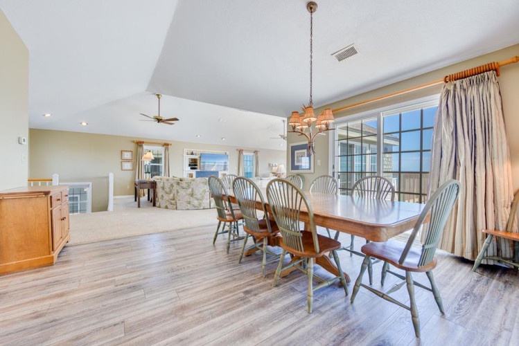 Gather around the spacious dining table, share meals, and make memories in this bright, open living space with vaulted ceilings and abundant natural light.
