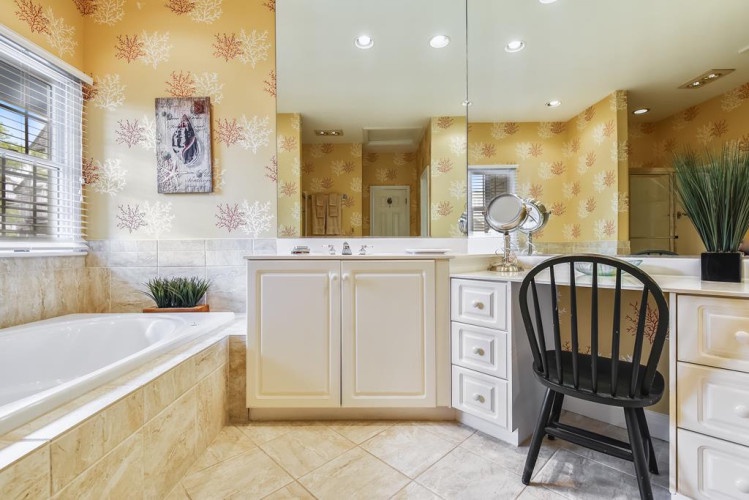 Unwind in your spa-like bathroom with a soaking tub, dual vanities, and cheerful coastal-inspired décor that makes every morning feel like a getaway.