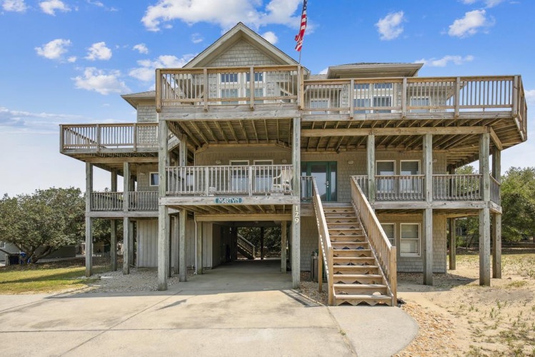 This elevated coastal retreat features expansive multi-level decks and covered parking, welcoming you to a distinctive vacation home near the shore.