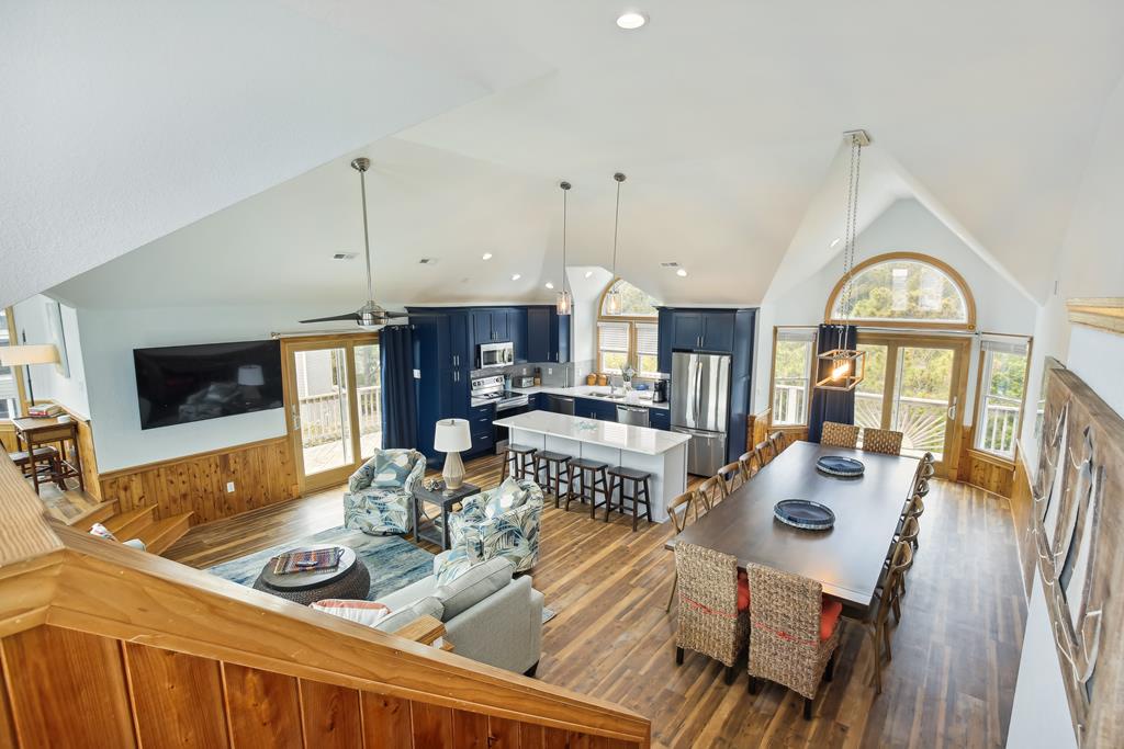 Spacious open-concept living with vaulted ceilings, where your group can gather for meals at the dining table, relax by the TV, or chat at the kitchen island—bright, airy, and perfect for togetherness.