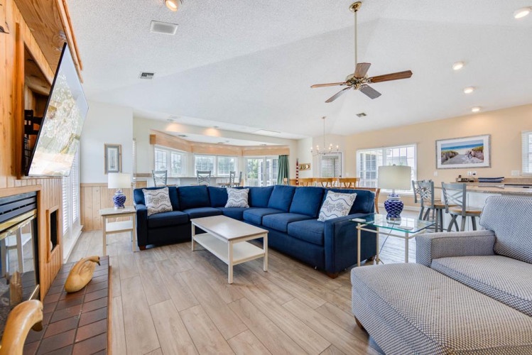 Imagine curling up on the spacious sectional in your bright, open-plan living space—perfect for family time or unwinding after a beach day.