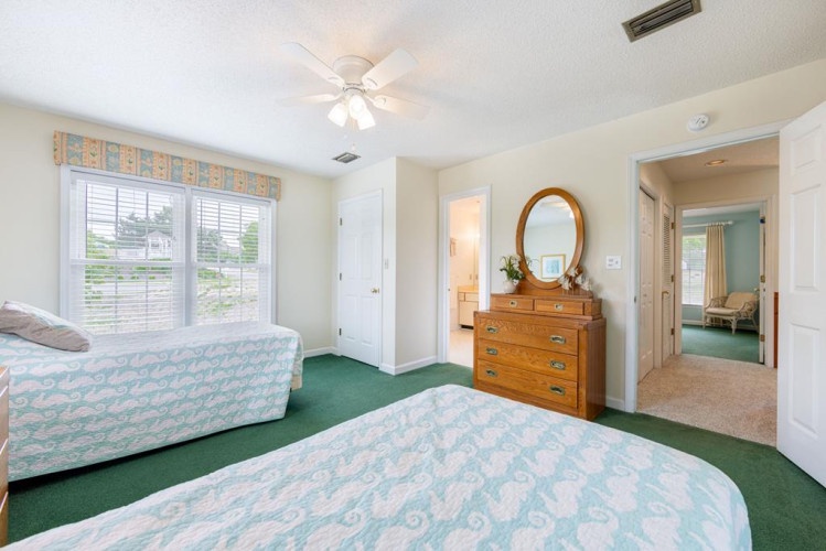 Wake up refreshed in this spacious bedroom, where twin beds offer flexible sleeping arrangements and a window seat brightens your morning with natural light, with views of the peaceful neighborhood beyond.
