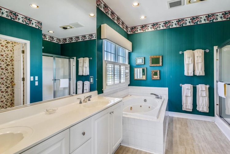 Soak away your cares in this elegant teal bathroom, where crisp white finishes meet charming accents. You'll love the spa-like atmosphere perfect for unwinding after a day of exploring.