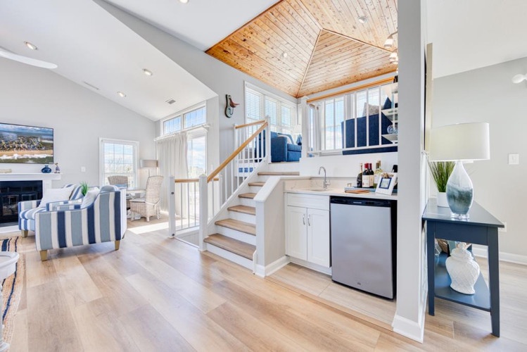 Relax in your stylish retreat with soaring ceilings, coastal-inspired décor, and a cozy loft above. Sunlight streams through generous windows, illuminating the open layout where you can unwind or whip up a snack in your convenient kitchenette.
