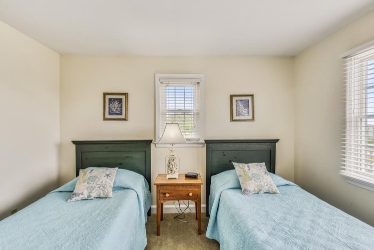 You'll find peaceful rest in this cozy bedroom with two twin beds dressed in soft blue linens, perfect for sharing with family or friends during your stay.