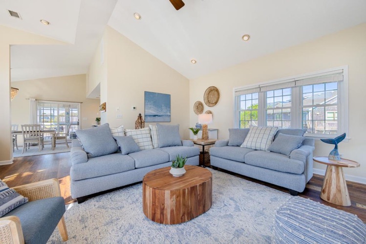 Sink into plush sofas and unwind in this airy living space, where vaulted ceilings and abundant natural light create the perfect setting for your coastal retreat.