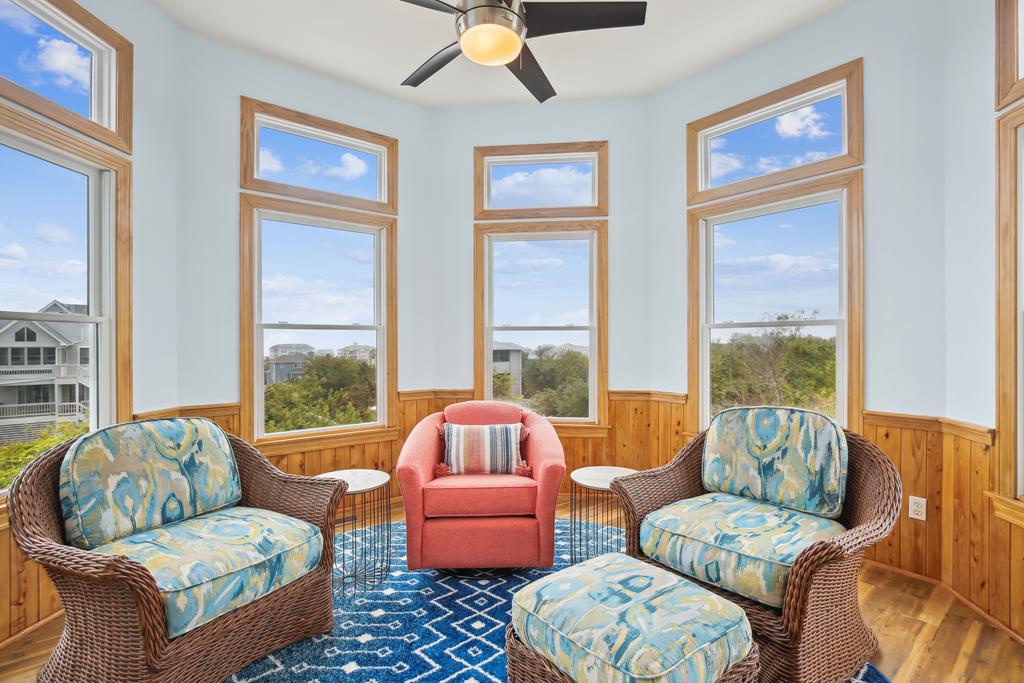 Sink into plush wicker seating and let the ceiling fan cool you as natural light pours through floor-to-ceiling windows. Your perfect spot to unwind with a book or morning coffee.