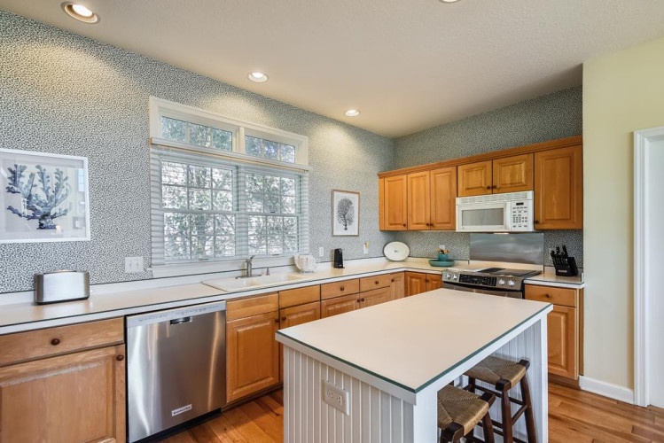 Cook memorable meals in your fully equipped kitchen with stainless steel appliances, gas range, dishwasher, and a spacious center island perfect for meal prep or casual dining.
