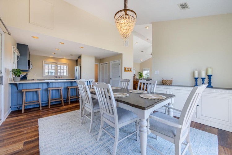 Gather around this elegant dining table where memories are made, with coastal-inspired décor and a sparkling chandelier setting the scene for your perfect getaway meals.