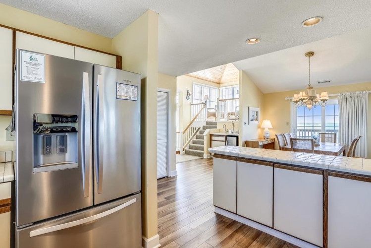 Step into a bright, open space where the modern kitchen flows seamlessly into your dining and living areas, with natural light streaming through windows and ocean views beckoning from your private balcony.