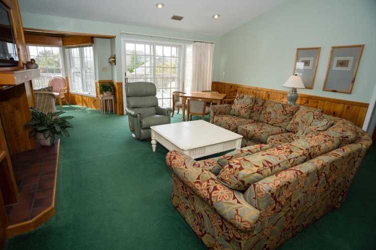 Your spacious living area invites relaxation with comfortable seating, natural light from French doors, and easy access to your private balcony overlooking scenic views.