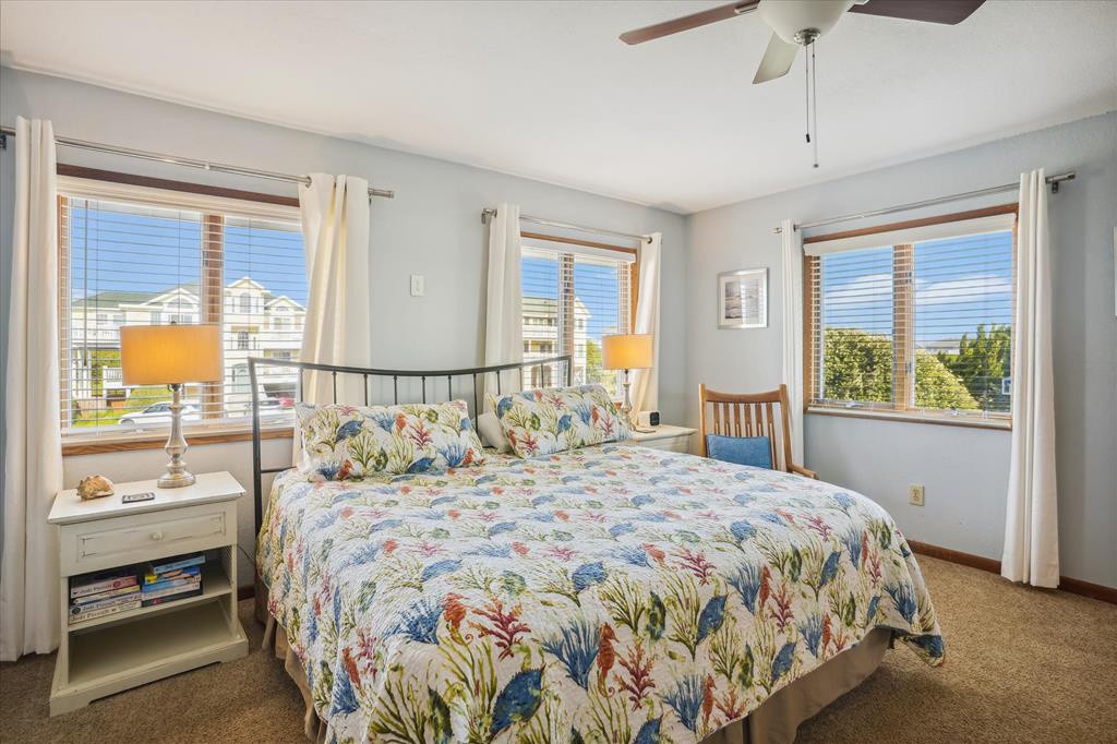 Wake up to soft natural light and refreshing coastal breezes in your serene bedroom. The cheerful bedding and breezy windows create a perfect retreat for restful nights.