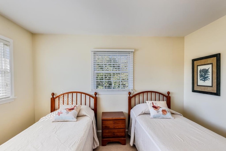 Cozy twin beds in your second bedroom await you and your travel companion, with warm wood tones, natural light, and peaceful décor that invites relaxation.
