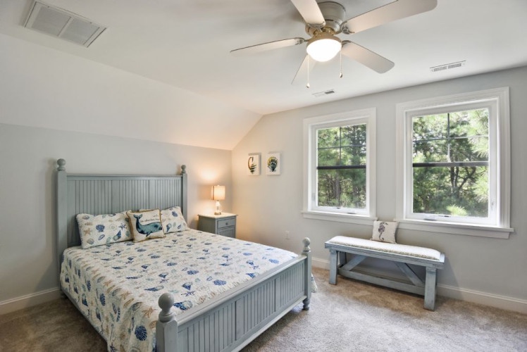 Unwind in your serene bedroom, where soft natural light filters through and a gentle ceiling fan keeps you cool. The cozy décor and peaceful forest views invite restful sleep after a day of adventure.
