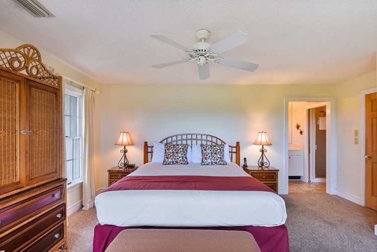 Sink into the cozy king bed under the gentle ceiling fan, where island-inspired décor and warm bedside lamps create your perfect retreat after a day exploring.