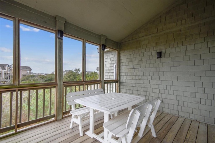 Your private screened porch offers serene views of coastal greenery, a perfect spot to savor morning coffee or unwind in the fresh air with a good book.