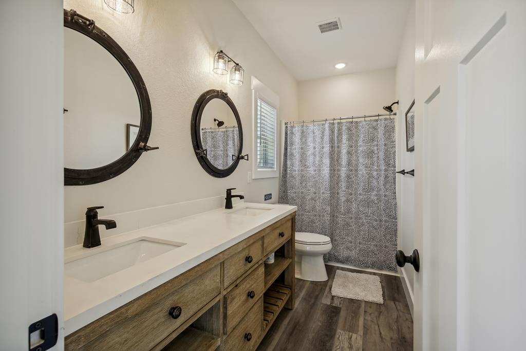 Step into your beautifully appointed bathroom, where rustic charm meets modern comfort. Enjoy the spacious dual vanity, elegant round mirrors, and a refreshing tub-shower combo—perfect for unwinding after a day of adventure.