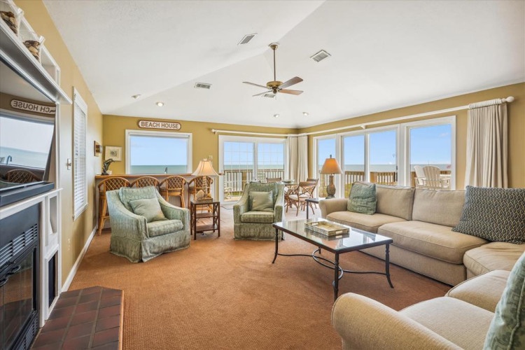 Picture yourself unwinding in this bright, oceanfront living room, where expansive windows frame endless beach and sea views. Sink into plush seating, feel the coastal breeze, and let the soothing sound of waves become your daily retreat.