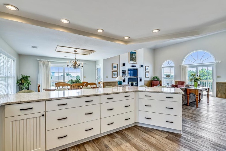This bright, open kitchen flows into your dining and living areas, offering stunning views through arched windows that frame lush gardens and inviting outdoor spaces.