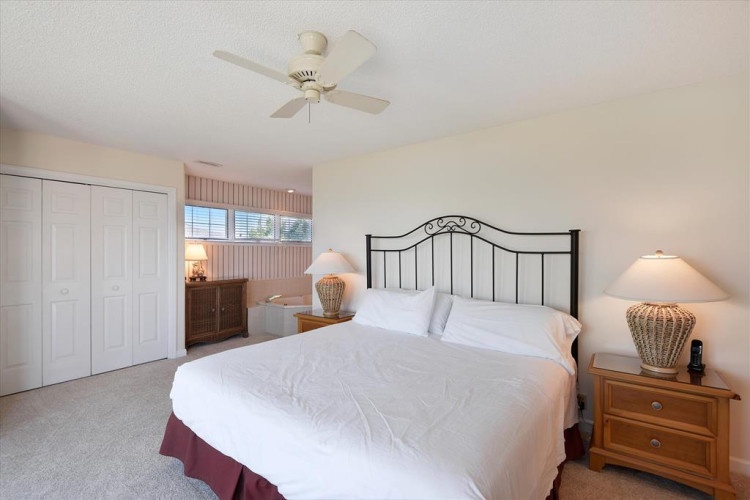 You'll drift off to restful sleep in this inviting bedroom with its plush bedding, soft lighting, and gentle ceiling fan overhead. Wake refreshed in this peaceful retreat.