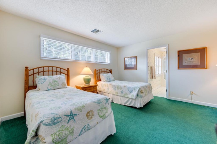 Your coastal-themed bedroom awaits with two comfy beds, perfect for family or friends traveling together. Natural light fills the room, creating a bright and cheerful retreat.