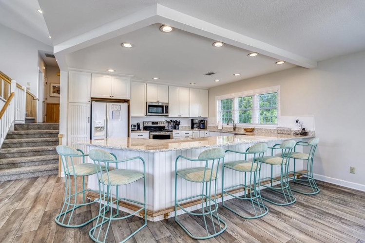 Gather around a spacious island with seating for everyone—your perfect spot for morning coffee, meal prep, or casual conversations. The bright, airy kitchen invites you to cook and connect.