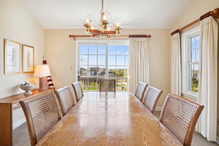 Gather around this spacious dining table with seating for eight, bathed in natural light from large windows overlooking peaceful neighborhood views.