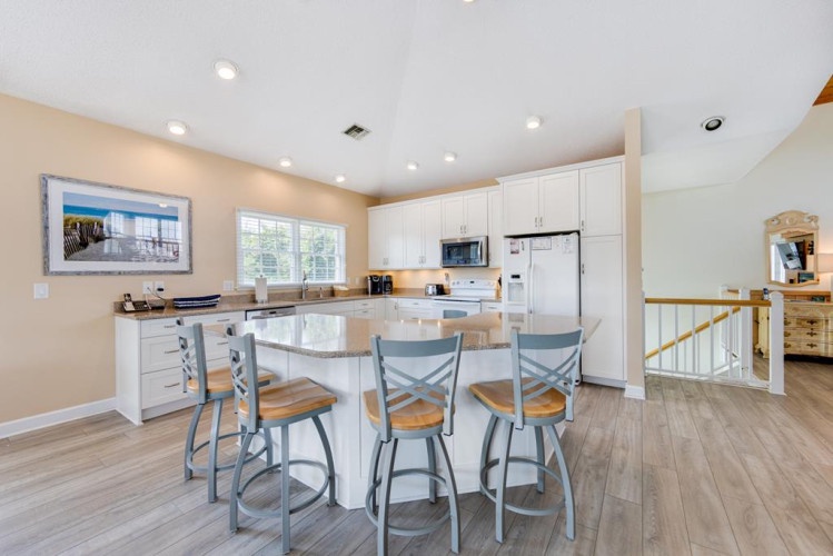 Your open-concept kitchen features sleek white cabinetry, granite countertops, and stainless appliances. Gather at the breakfast bar for morning coffee or casual meals together.