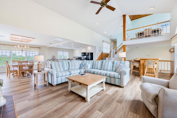 Sink into your plush seating and enjoy the bright, airy open-concept living space. Vaulted ceilings, coastal-inspired décor, and easy flow between living, dining, and kitchen make this your perfect home away from home.