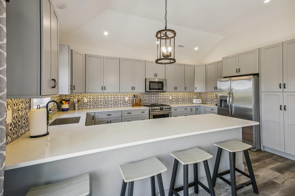 Gather around this bright, fully-equipped kitchen with its stylish island seating and modern appliances—perfect for preparing meals together or enjoying your morning coffee.