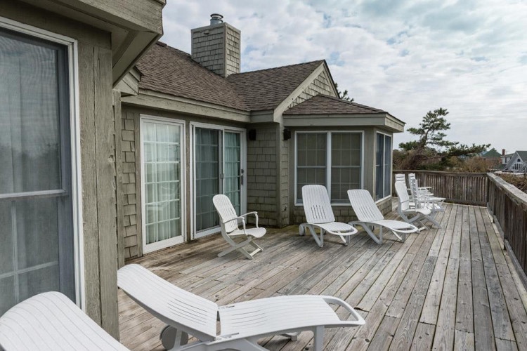 Stretch out on this spacious deck with plenty of lounge chairs for soaking up coastal breezes. Your perfect spot to unwind and enjoy the peaceful surroundings.