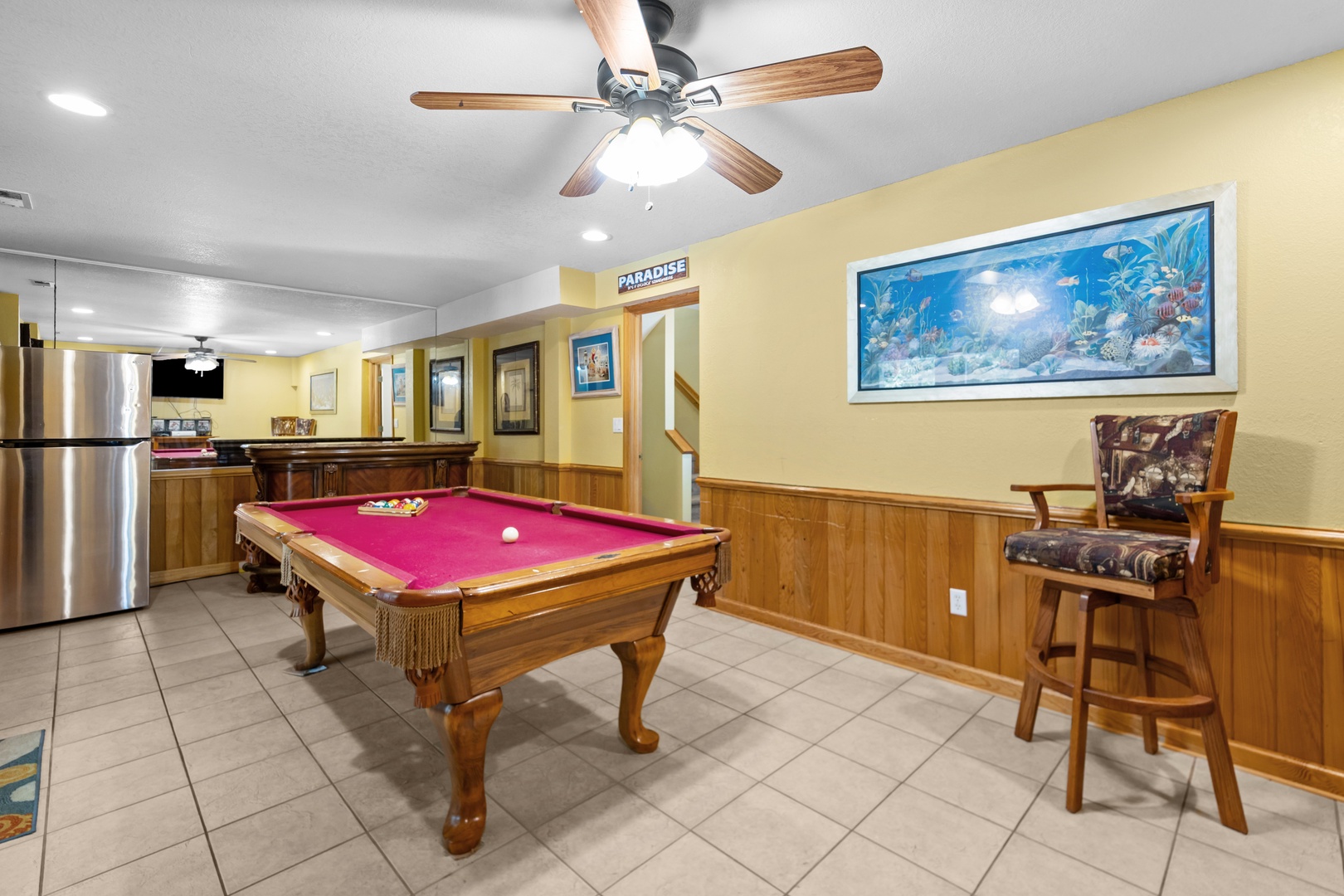 Step into your own game room paradise. Rack up some fun on the full-size billiards table, unwind with a cool drink from the mini fridge, and let the tropical artwork transport you to island mode.