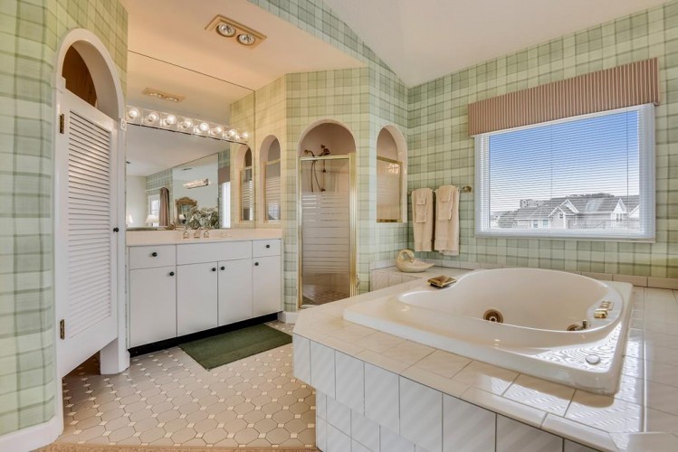 Your private retreat features a soaking tub, double vanity, and charming architectural details that invite relaxation and indulgence after a day of exploring.
