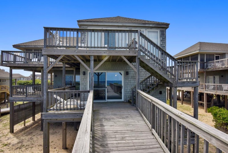 A stunning beachfront property elevated on sturdy pilings, featuring expansive wrap-around decks where you can soak in breathtaking ocean views from multiple levels.