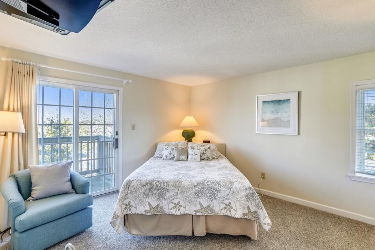 Your serene bedroom features a plush bed, cozy armchair, and balcony access—perfect for morning coffee or evening relaxation with a view.