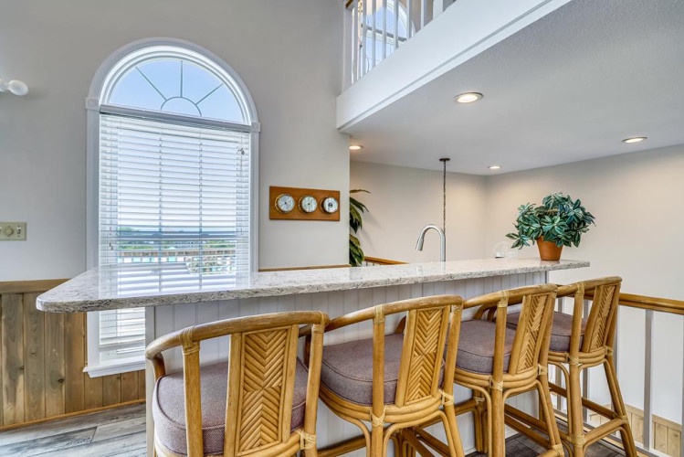 Gather at the granite-topped breakfast bar with ample seating and let natural light from the arched window enhance your morning coffee ritual. The open layout invites you to unwind and connect.