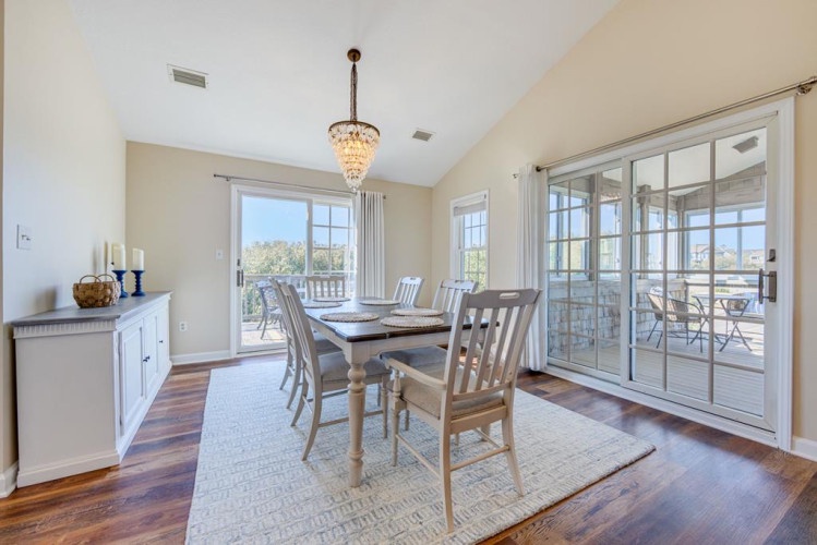 Sunlit dining space frames outdoor vistas, inviting you to savor meals surrounded by natural light and scenic views through expansive glass doors.