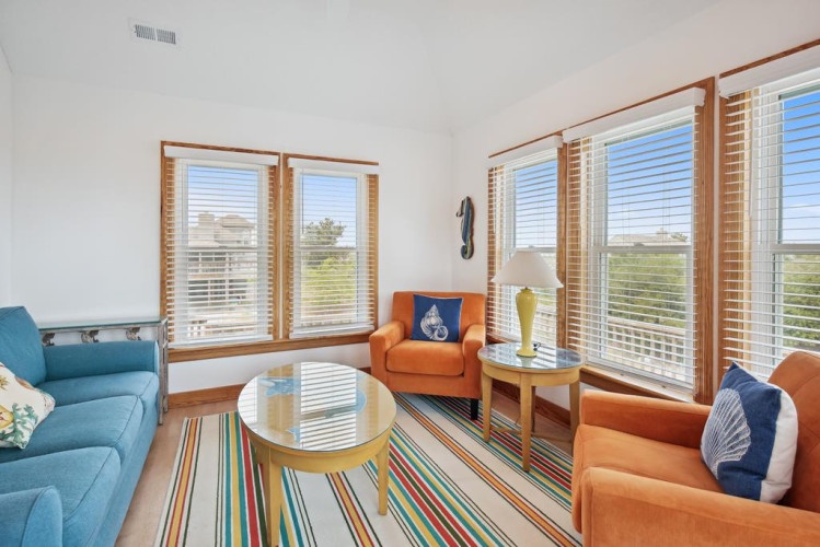Sink into plush seating and let the coastal breeze fill your bright, sun-drenched living space. Large windows frame peaceful views, inviting you to relax and unwind in comfort.