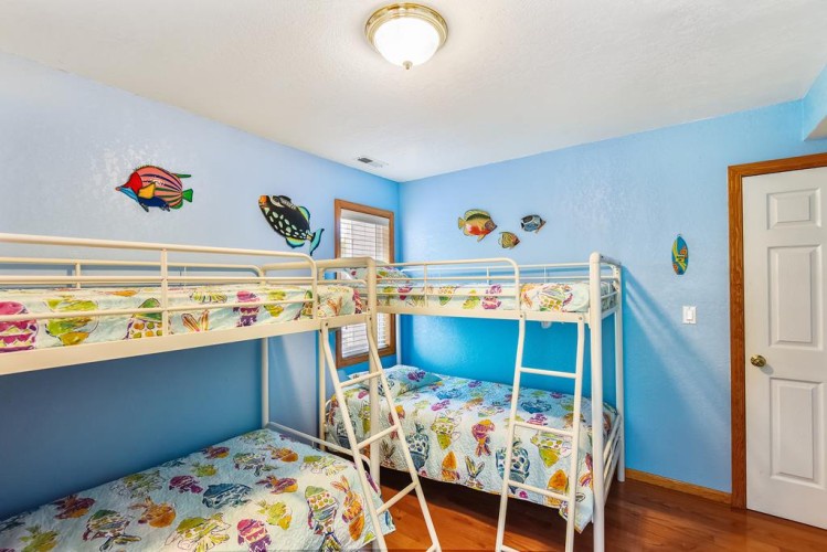 Your kids will love this ocean-themed room with bunk beds and colorful fish decorations. Bright walls and cheerful bedding create a fun, playful space for little adventurers.
