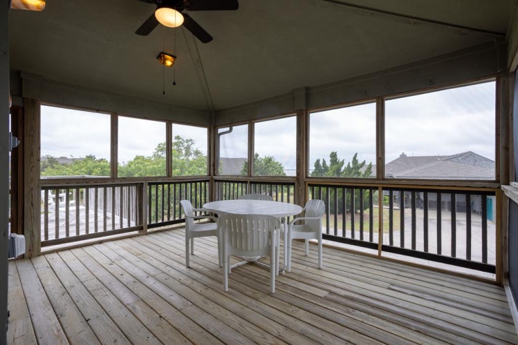 Your private screened porch offers a peaceful retreat with natural views, ceiling fan comfort, and a cozy dining setup perfect for morning coffee or evening meals.