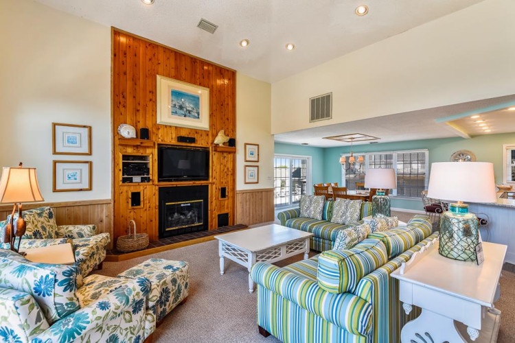 Unwind in your bright living space with coastal charm, soft seating, and a cozy fireplace waiting to warm your evenings.
