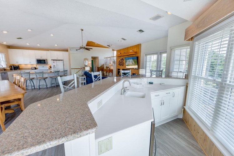 Step into your spacious open-concept kitchen and living area, where natural light pours through plantation shutters and modern appliances await your culinary adventures. Gather with loved ones at the expansive island or unwind in the cozy lounge—your coas