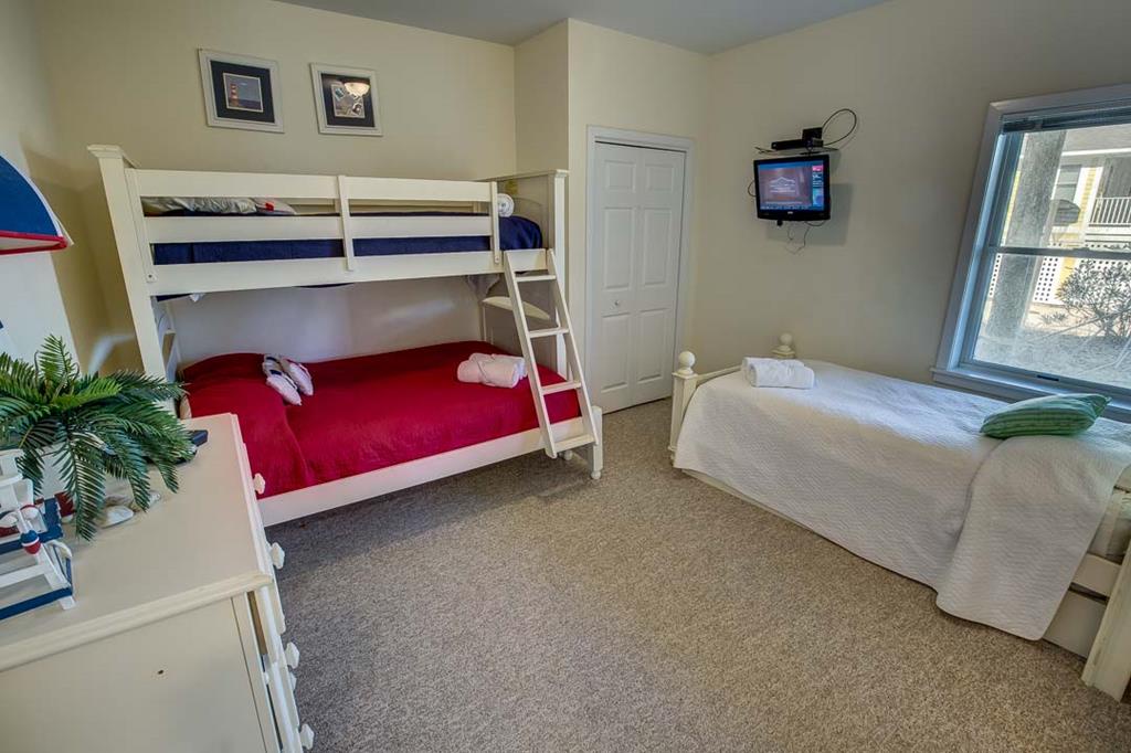 Your family's home away from home features a fun bunk bed setup plus an extra bed, all dressed with crisp linens. Watch your favorite shows on the wall-mounted TV or enjoy sunny views from the bright window.