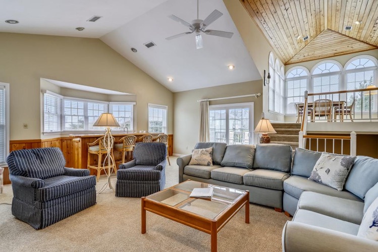 Step into your spacious living room with vaulted ceilings and natural light pouring through large windows. Relax on comfortable seating while you enjoy the open, airy atmosphere.
